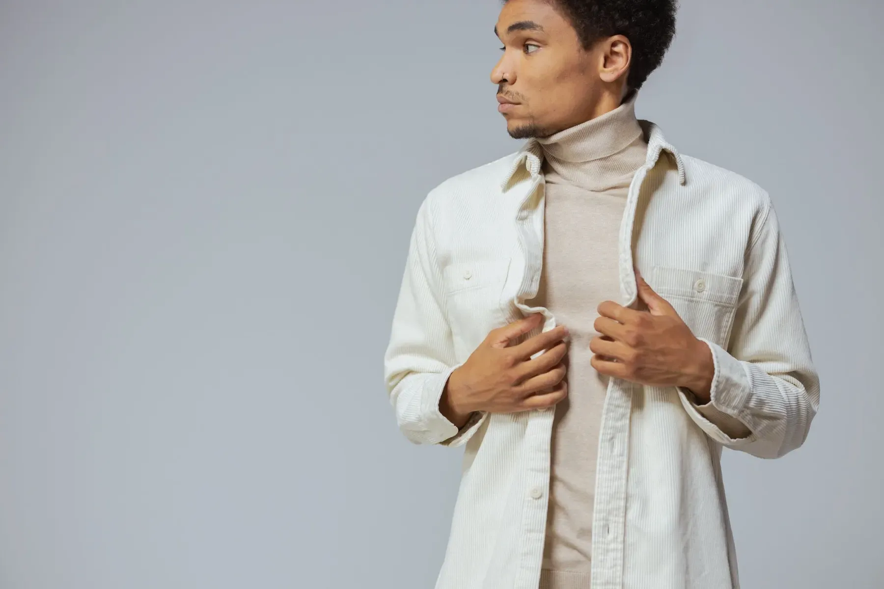 Model fastening an ecru handloom overshirt over a beige knit